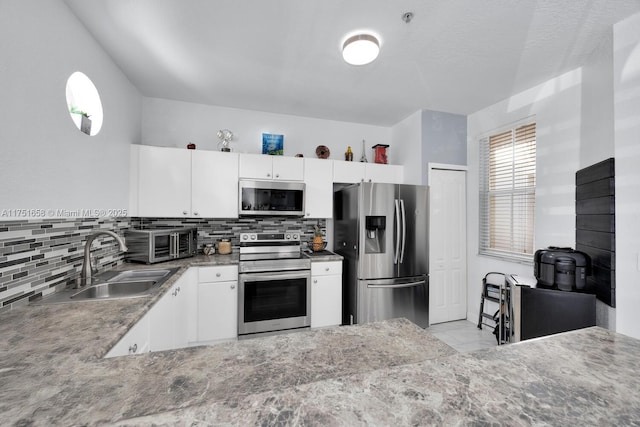 4331 SW 160th Ave Unit 108, Miramar, FL 33027 - kitchen featuring stainless steel appliances, a sink, decorative backsplash, tile patterned flooring, and white cabinets