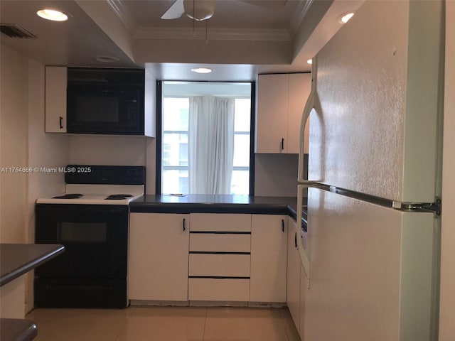 kitchen with black microwave, range with electric stovetop, freestanding refrigerator, and crown molding