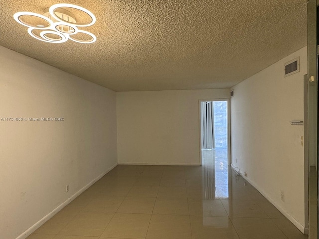 851 Three Islands Blvd Unit 411, Hallandale Beach, FL 33009 - unfurnished room featuring a textured ceiling, baseboards, and light tile patterned floors