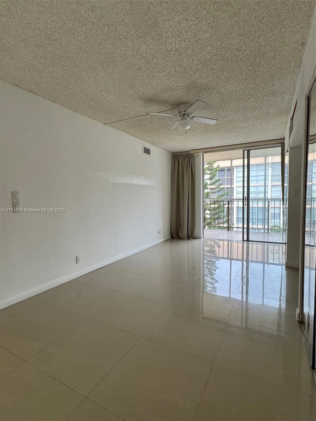 851 Three Islands Blvd Unit 411, Hallandale Beach, FL 33009 - empty room with a ceiling fan, a wall of windows, baseboards, and tile patterned flooring
