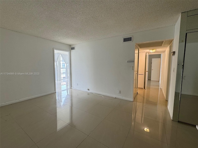 851 Three Islands Blvd Unit 411, Hallandale Beach, FL 33009 - unfurnished room with baseboards, a textured ceiling, and light tile patterned floors