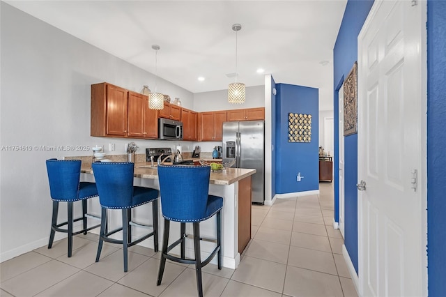 25340 SW 116th Ave, Homestead, FL 33032 - kitchen with a peninsula, a breakfast bar, pendant lighting, and stainless steel appliances