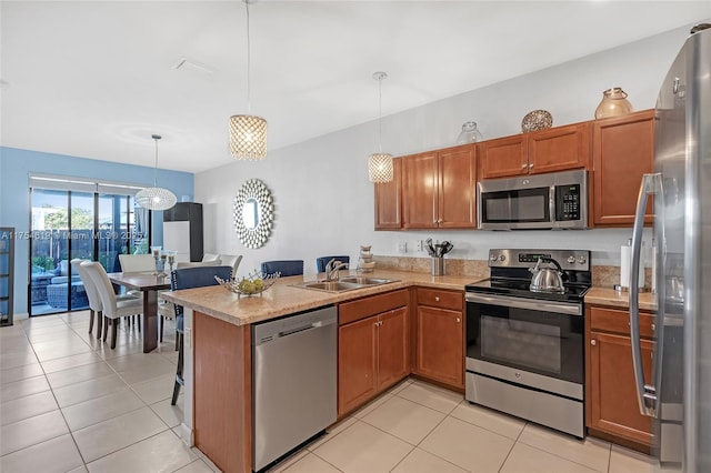 25340 SW 116th Ave, Homestead, FL 33032 - kitchen with stainless steel appliances, light countertops, brown cabinetry, a sink, and a peninsula