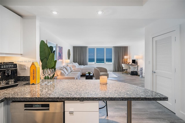 kitchen featuring white cabinetry, open floor plan, dishwasher, and wood finished floors