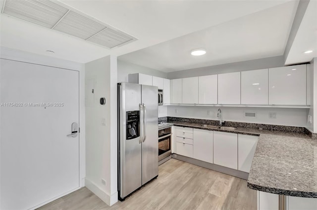 kitchen featuring light wood-style flooring, visible vents, stainless steel appliances, and a sink