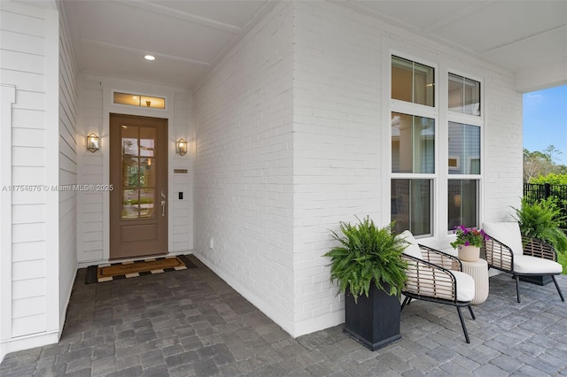 entrance to property with covered porch and brick siding