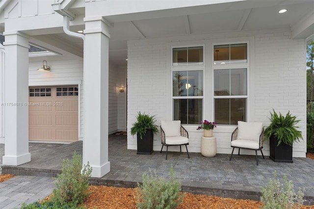 view of patio featuring a garage and a porch