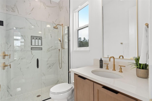 bathroom with vanity, a marble finish shower, and toilet