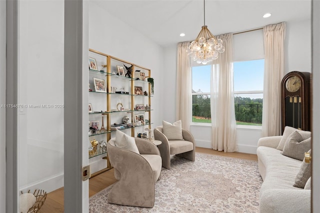 living area with a notable chandelier, baseboards, wood finished floors, and recessed lighting