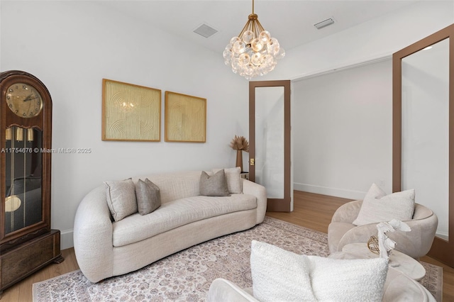 living room featuring visible vents, baseboards, and wood finished floors