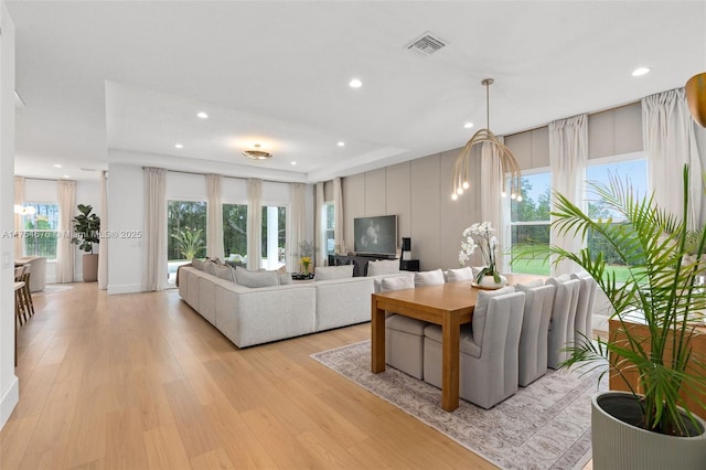 living room featuring light wood finished floors, visible vents, a chandelier, and recessed lighting