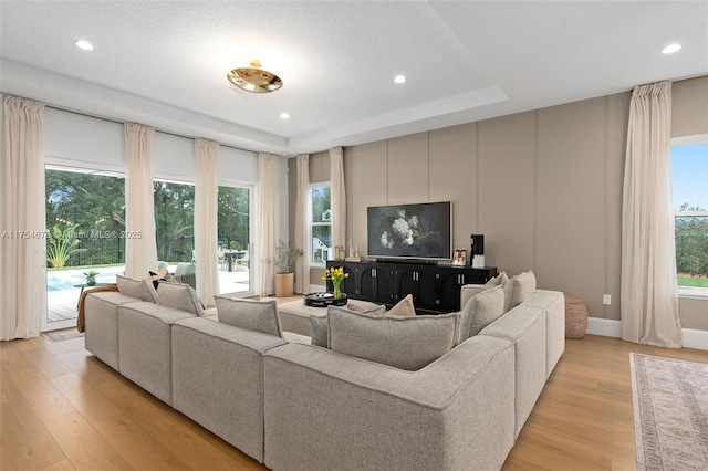 living room with recessed lighting, light wood-style flooring, and baseboards