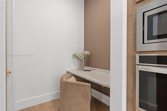 interior space with baseboards and wood finished floors