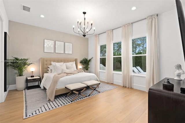 bedroom featuring recessed lighting, visible vents, light wood finished floors, and an inviting chandelier