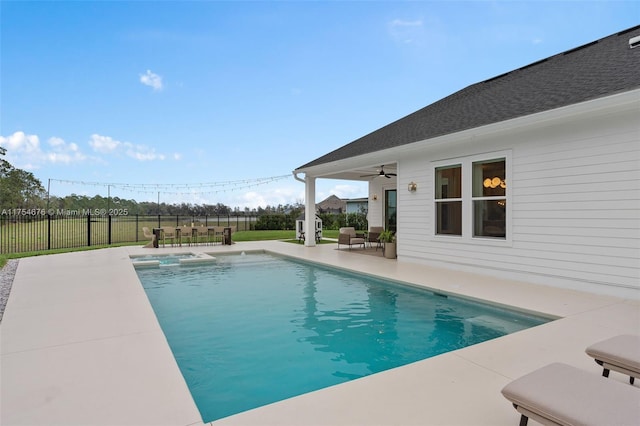 view of pool with a ceiling fan, a pool with connected hot tub, fence, and a patio