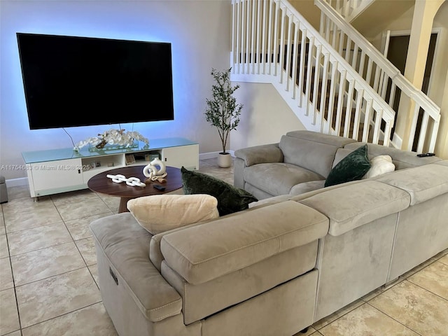 living room featuring light tile patterned flooring, stairway, and baseboards