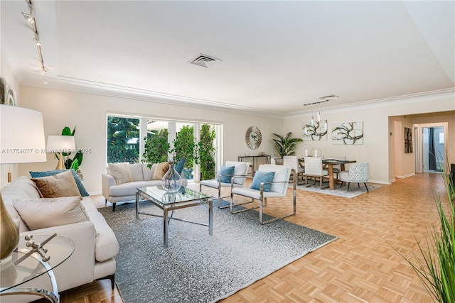 living room featuring ornamental molding, rail lighting, visible vents, and baseboards