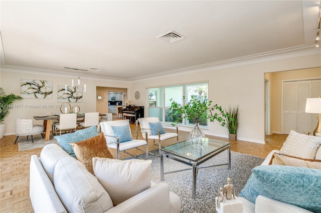 living room featuring baseboards, visible vents, and crown molding