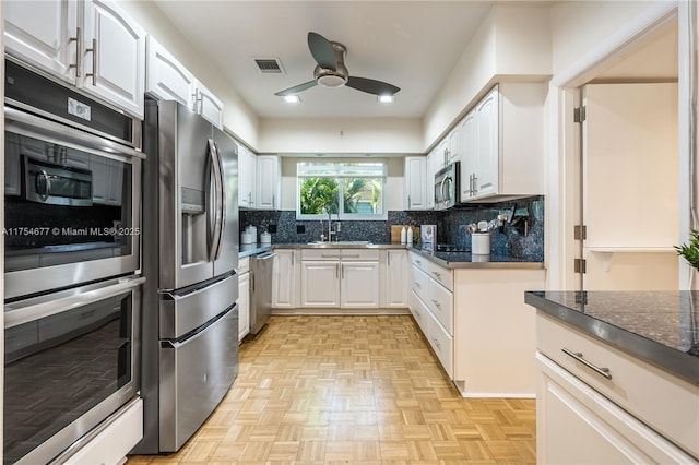 kitchen featuring a ceiling fan, visible vents, a sink, appliances with stainless steel finishes, and tasteful backsplash