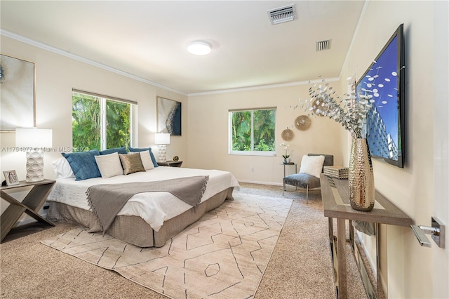 carpeted bedroom with crown molding, multiple windows, and visible vents