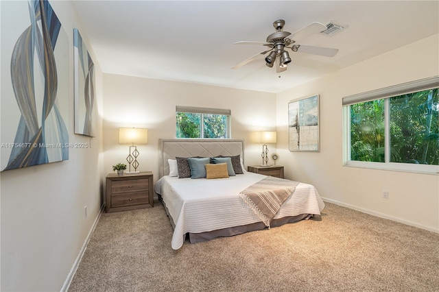 carpeted bedroom with visible vents, a ceiling fan, and baseboards