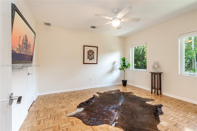 interior space with a wealth of natural light, baseboards, and a ceiling fan