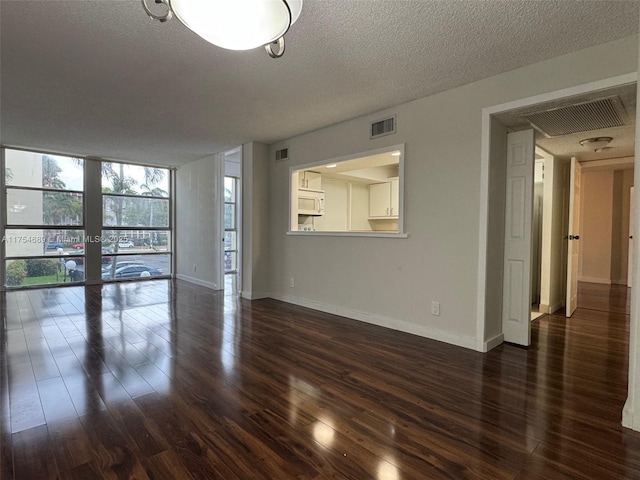 851 Three Islands Blvd Unit 218, Hallandale Beach, FL 33009 - empty room with dark wood-style flooring, a textured ceiling, baseboards, french doors, and floor to ceiling windows