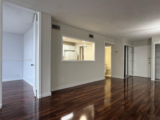 851 Three Islands Blvd Unit 218, Hallandale Beach, FL 33009 - spare room featuring a textured ceiling, wood finished floors, and baseboards