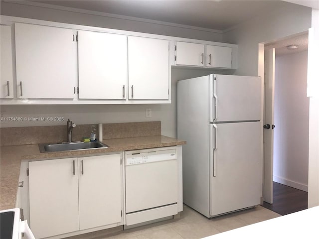 kitchen with light countertops, white appliances, a sink, and white cabinets