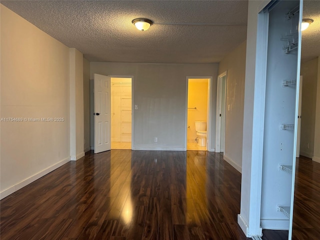 851 Three Islands Blvd Unit 218, Hallandale Beach, FL 33009 - unfurnished room with dark wood-style floors, a textured ceiling, and baseboards