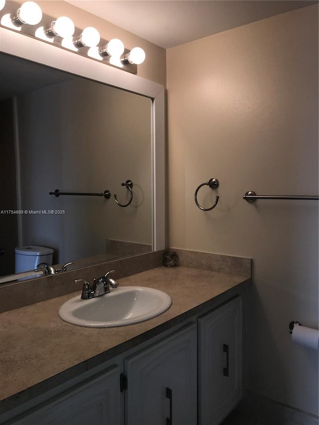 bathroom featuring vanity and toilet