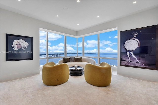 living area featuring a water view and baseboards