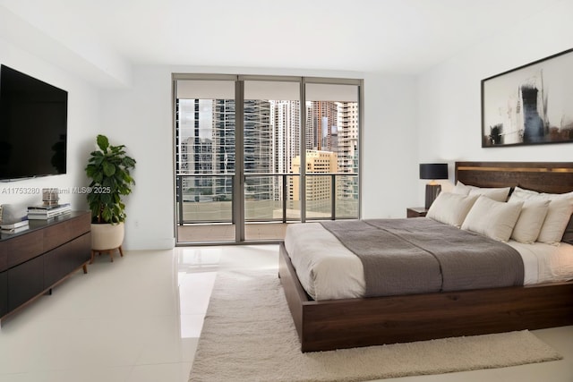 bedroom featuring light tile patterned floors, a wall of windows, and access to exterior