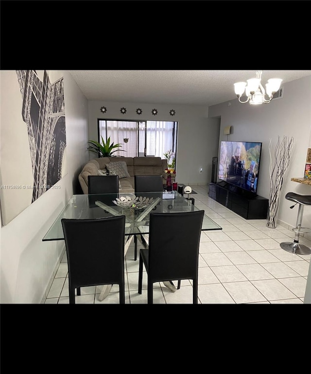 dining area with light tile patterned floors, a textured ceiling, baseboards, and a notable chandelier