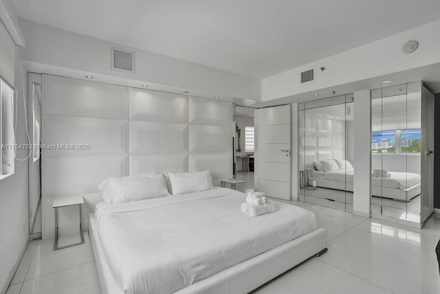 tiled bedroom featuring visible vents and multiple windows