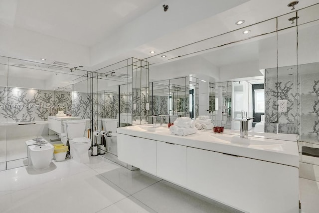 bathroom featuring a sink, tile walls, toilet, and double vanity