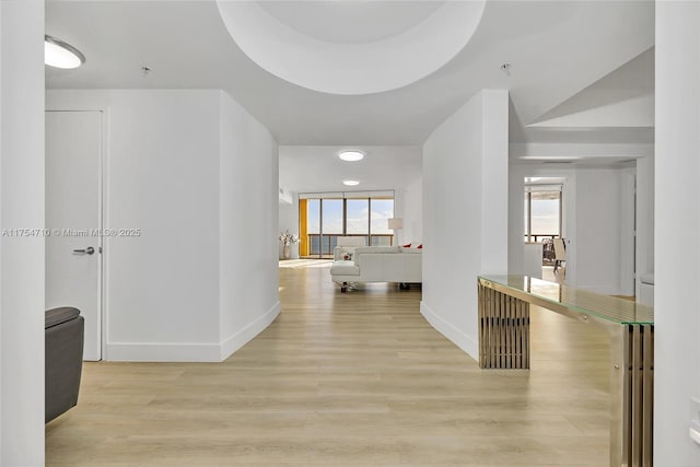 hallway with light wood-style floors and baseboards