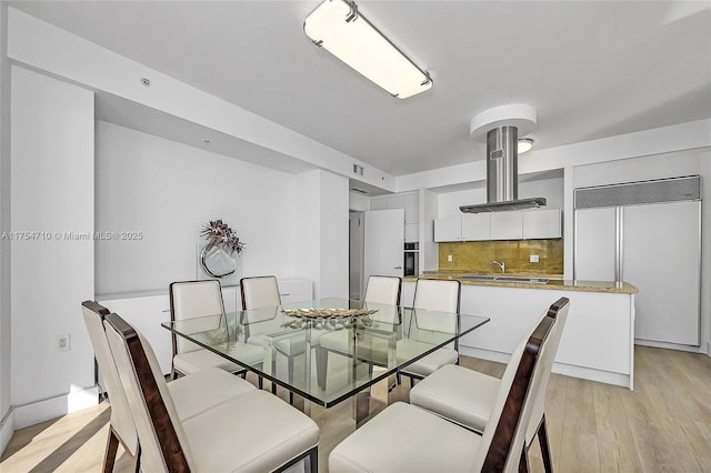 dining room with light wood-type flooring and visible vents