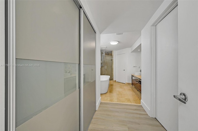 corridor with light wood-style floors