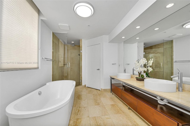 bathroom with a freestanding tub, a sink, a shower stall, and double vanity