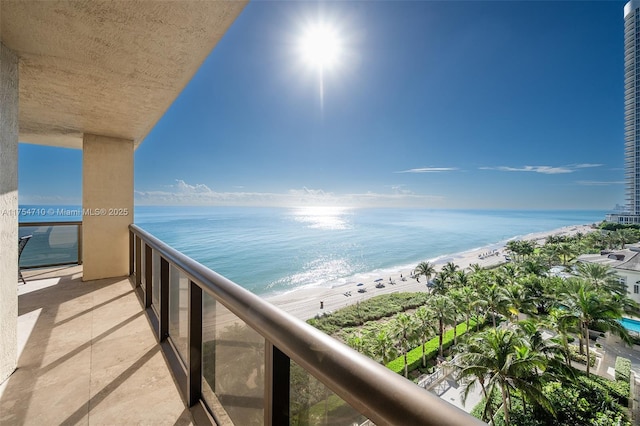 balcony with a water view and a beach view