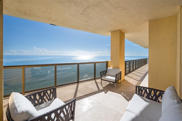 balcony featuring a water view and an outdoor living space