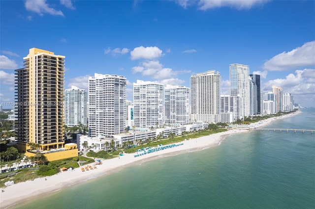 drone / aerial view featuring a view of the beach, a city view, and a water view