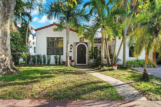 mediterranean / spanish-style house with stucco siding and a front lawn
