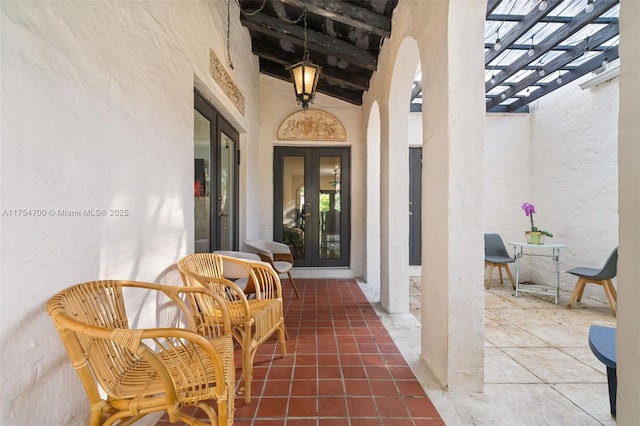 doorway to property with french doors, a pergola, and stucco siding