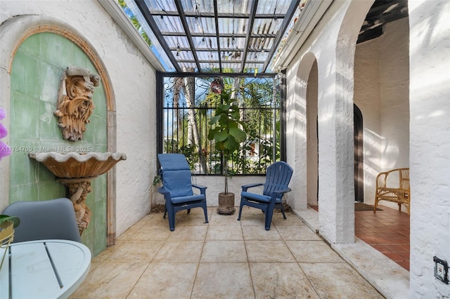 sunroom featuring arched walkways and a healthy amount of sunlight