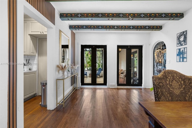 entrance foyer featuring beam ceiling, baseboards, wood finished floors, and french doors