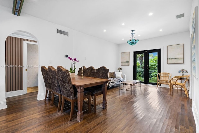 dining space featuring visible vents, arched walkways, wood finished floors, and french doors