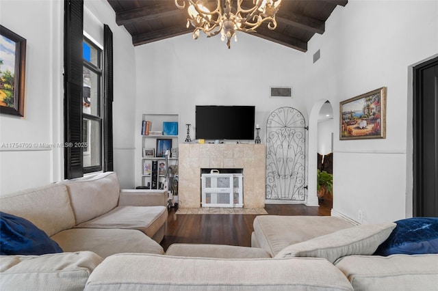 living room with visible vents, arched walkways, wooden ceiling, wood finished floors, and a fireplace