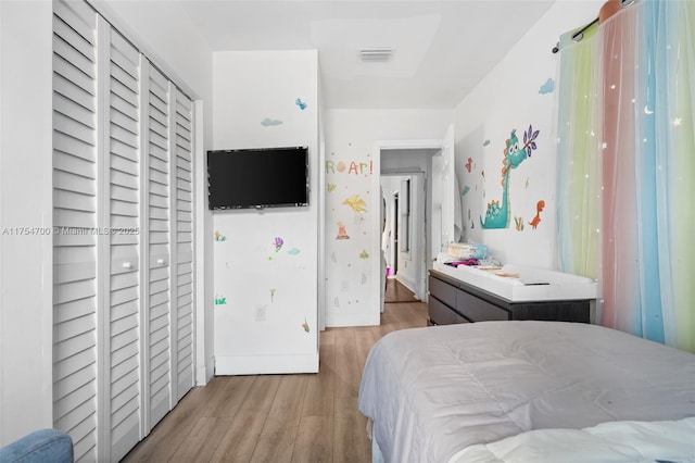 bedroom featuring wood finished floors, visible vents, and baseboards